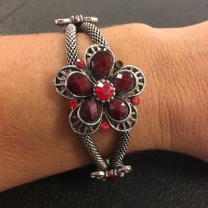 Silver clasp bracelet with ruby red flower